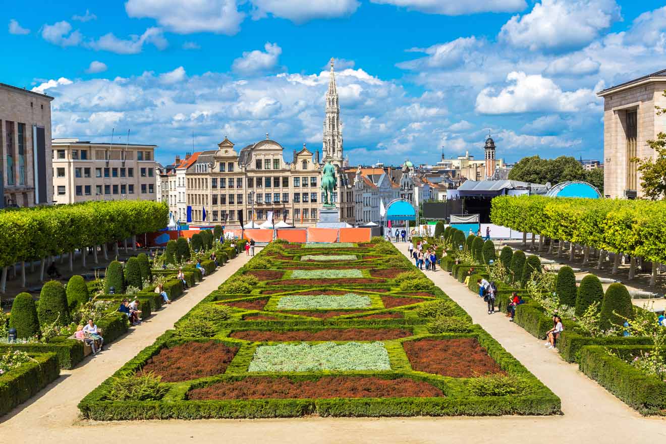 Vibrant Mont des Arts garden with geometric shrubbery and the Town Hall spire in the background, Brussels